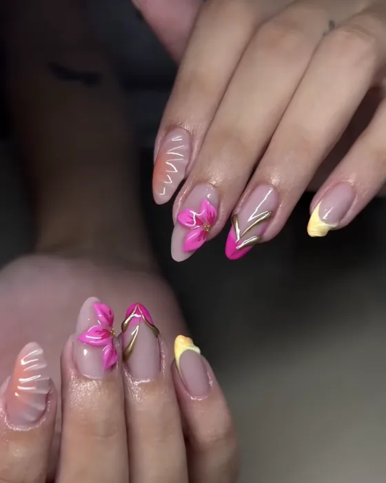 Nail art rose et doré avec fleurs en relief sur une manucure amande